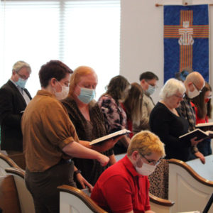 Families gathered to sing hymns from the pews. Congregants are masked as a precaution during the COVID-19 pandemic.